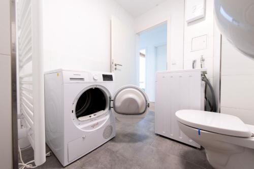 uma casa de banho branca com uma máquina de lavar roupa e um WC em Stay and Work Apartment - 8 single beds - central em Gronau