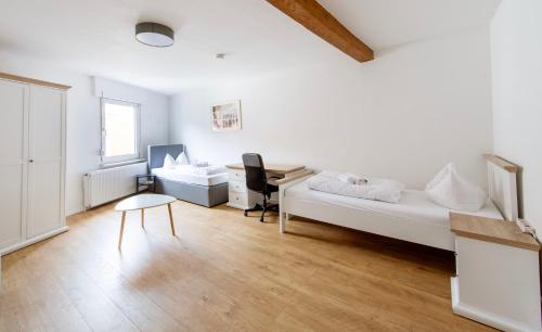 um quarto com uma cama, uma secretária e uma cadeira em Stay and Work Apartment - 8 single beds - central em Gronau