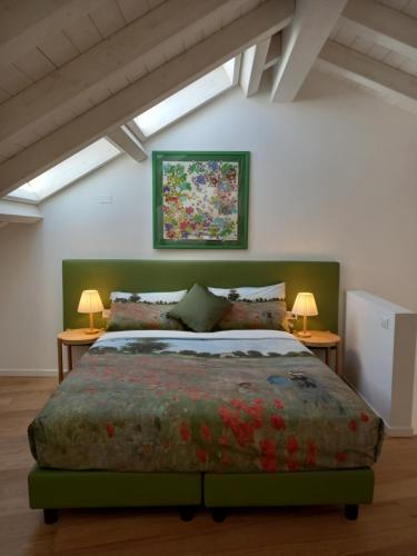 納維廖河畔切爾努斯科的住宿－Vivila - Ca' Foulard，卧室配有一张大床,墙上挂有绘画作品
