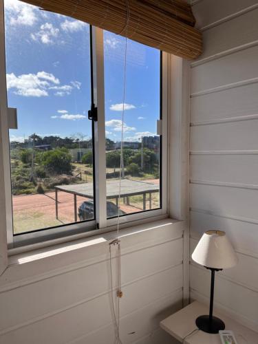 ventana en una habitación con lámpara y vistas en Casitas Punta del Diablo, en Punta del Diablo