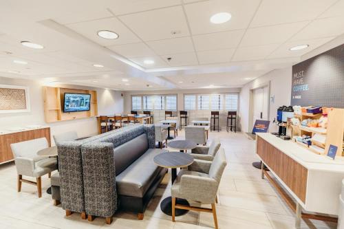 a waiting room with couches and tables and chairs at Holiday Inn Express Atlanta - Northeast I-85 - Clairmont Road by IHG in Atlanta
