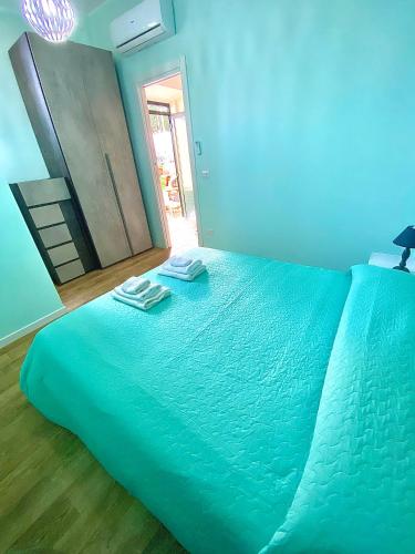 a blue bed with two towels on top of it at Bilocale Nucarella in Scilla