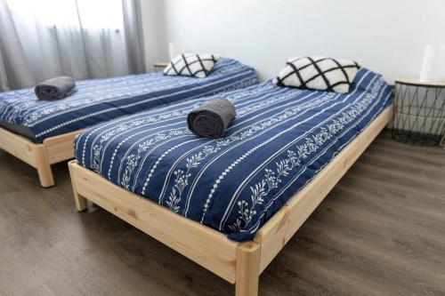 2 Einzelbetten in einem Schlafzimmer mit blauer und weißer Bettwäsche in der Unterkunft Maison au pied du château N°2 in Châteaudun
