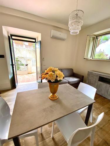 a dining room table with a vase of flowers on it at Bilocale Nucarella in Scilla