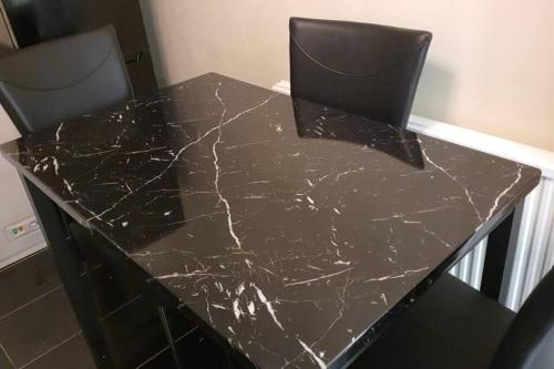 a black marble table with two chairs in a room at 2 Bedroom Flat in Vauxhall, London in London