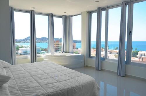 a bedroom with a bed and views of the ocean at Suites Rubí - Las Mejores vistas de San Carlos in San Carlos