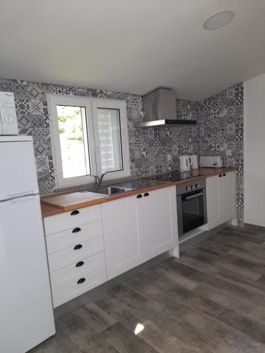 a kitchen with white cabinets and a window at Atlantico in Geres