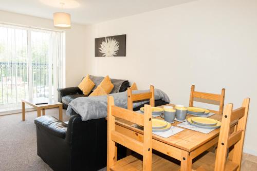 a living room with a table and a couch at Greenings Apartment Warrington - 2 Bed with FREE off road Parking in Warrington