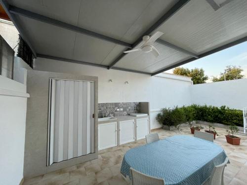 a patio with a table and a ceiling fan at Il mare di Totino - Seaside guest house - Torre San Giovanni in Torre San Giovanni Ugento