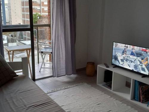 a living room with a flat screen tv on a table at DEPARTAMENTO CÉNTRICO, a METROS de la UNIVERSIDAD, 3 PERSONAS in La Plata