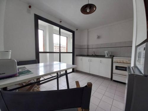 a kitchen with a table and a table and a kitchen with a stove at DEPARTAMENTO CÉNTRICO, a METROS de la UNIVERSIDAD, 3 PERSONAS in La Plata