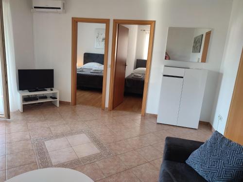 a living room with a couch and a television and a bedroom at Apartments Lorena in Poreč