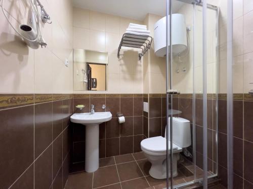 a bathroom with a toilet and a sink at Hotel Rita House in Pizunda