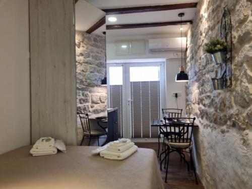 a room with a table and chairs and a stone wall at Sea Star in Tribunj