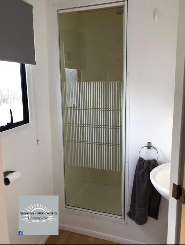 een glazen douche in een badkamer met een wastafel bij Skegness - Ingoldmells Caravan Hire in Ingoldmells