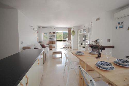 - une cuisine blanche avec une grande table et des chaises dans l'établissement PENTHOUSE COSTA DEL SOl, à Benahavís