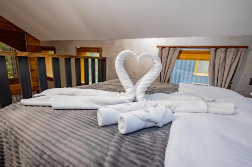 - un lit avec des serviettes blanches en forme de cœur dans l'établissement Safir Doğa Evleri, à Rize