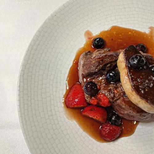 a plate of food with pancakes and berries on it at Hostal de la Plaça - Hotel Boutique in Cabrils