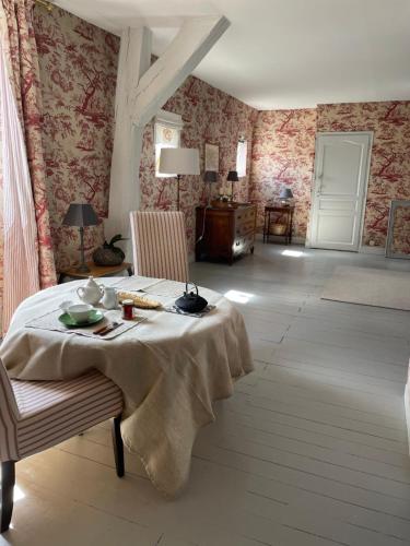 Belle Fontaine في بورج: غرفة طعام مع طاولة وكراسي وجدران وردية