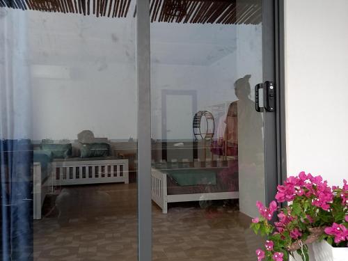a glass door with a reflection of two babies in a room at Chunlii Homestay in Ke Ga
