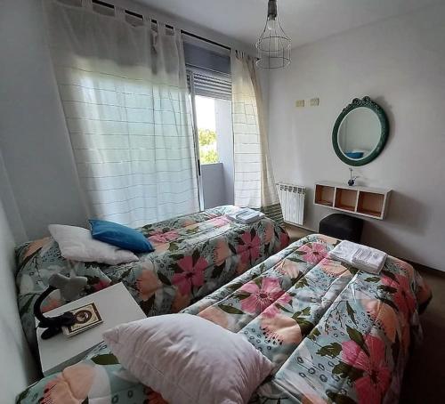 a bedroom with two beds and a mirror at DEPARTAMENTO a PASOS del CENTRO, BARRIO NORTE, 4 PERSONAS in La Plata