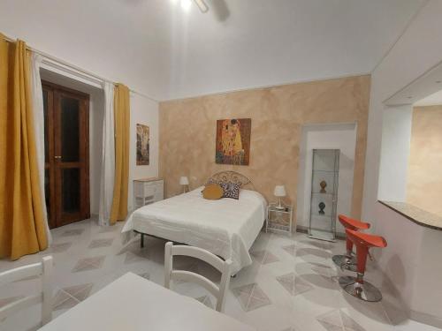 1 dormitorio con 1 cama, mesa y sillas en GL Golden City Apartments, en Catania