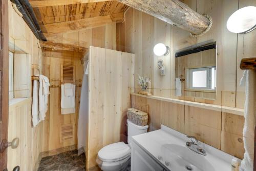 a bathroom with wooden walls and a toilet and a sink at Remote Escape Klamath Falls Cabin By Lake and Hikes in Klamath Falls