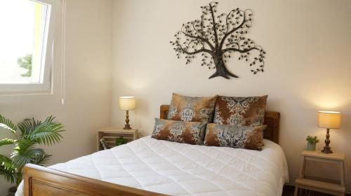 um quarto com uma cama com uma árvore na parede em Casa do Areal em Mira