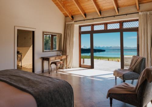 a bedroom with a bed and a view of the ocean at Mt Cook Lakeside Retreat in Lake Pukaki