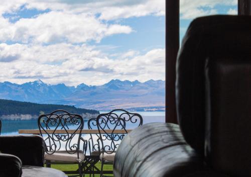 a view of the mountains from a room with benches at Mt Cook Lakeside Retreat in Lake Pukaki