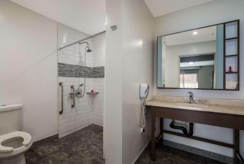 a bathroom with a sink and a shower and a phone at Sunset West Hotel, SureStay Collection By Best Western in Los Angeles