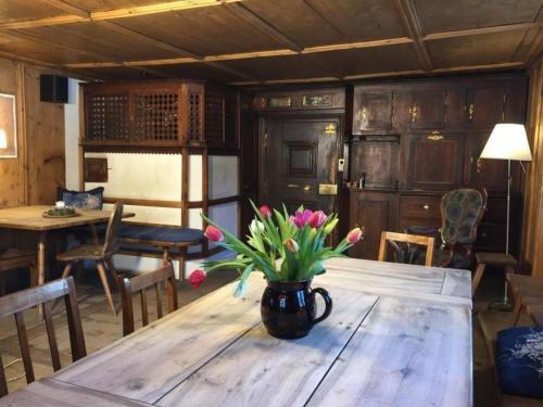 a vase of flowers sitting on a wooden table at Posta Veglia in Sils Baselgia