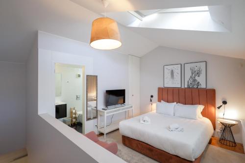 a bedroom with a large bed and a tv at Douro Destilaria Residence by Porto City Hosts in Vila Nova de Gaia