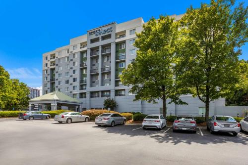 a hotel with cars parked in a parking lot at Sonesta Select Atlanta Midtown Georgia Tech in Atlanta