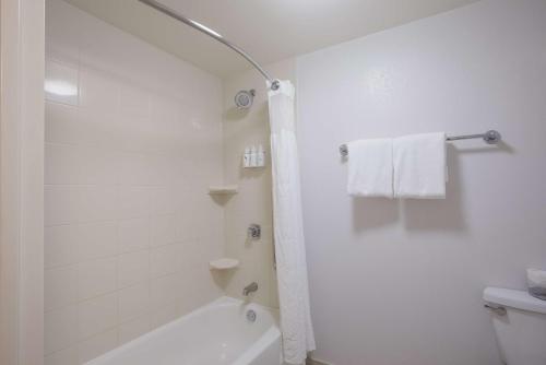 a white bathroom with a tub and a toilet at Sonesta Select Atlanta Midtown Georgia Tech in Atlanta