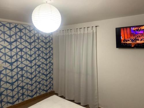 a room with a television and a white curtain at Cassanova III in San Luis