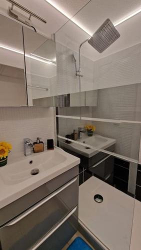 une salle de bain blanche avec un lavabo et un miroir dans l'établissement magnifique APPARTEMENT vue mer Parking Piscine Plage Climatisé, à Cannes