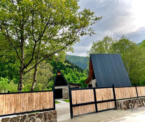 a wooden fence in front of a house at Cottage Orcs in Borjomi