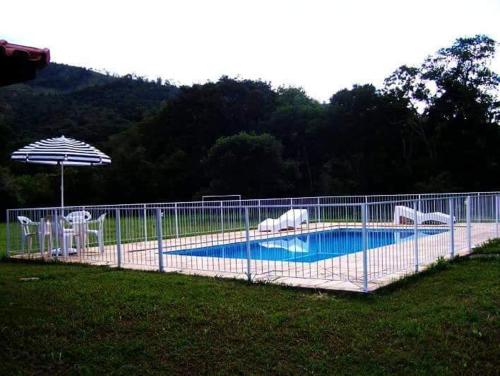 a fence around a swimming pool in a yard at Pousada Terra Nostra in Serra Negra