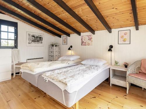 a bedroom with a large bed and a wooden ceiling at Holiday home Væggerløse VII in Marielyst