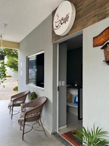 een lobby met twee stoelen en een bord op een restaurant bij São José Village in Sobral