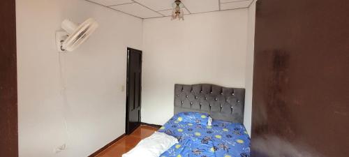 a bedroom with a bed with a blue comforter at Aparta Hotel el Castillo in Melgar