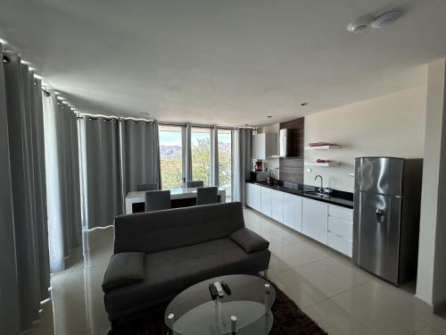 a living room with a couch and a kitchen at Suites Rubí - Las Mejores vistas de San Carlos in San Carlos