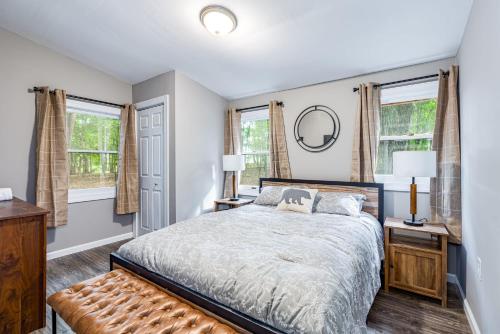 una camera da letto con un letto e due finestre di Cozy & Modern w Hot Tub, Fire Pit, Grill & Pond a Morton Grove