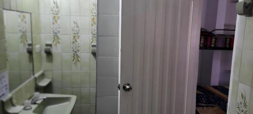 a bathroom with a sink and a white door at Aparta Hotel el Castillo in Melgar