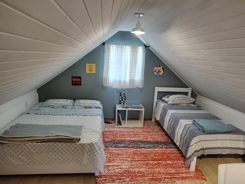um quarto no sótão com 2 camas e uma janela em Quarto de solteiro/casais em Teresópolis
