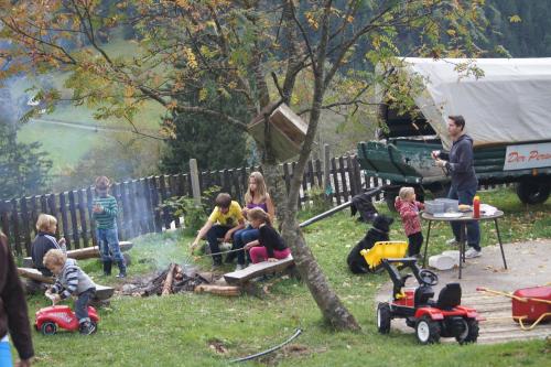 a group of children sitting around a fire in a yard at Der Perweinhof in Donnersbachwald