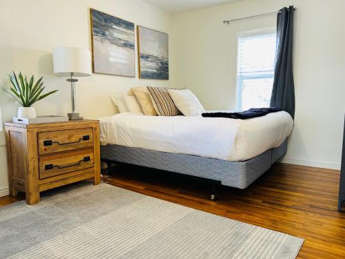 a bedroom with a bed and a table with a lamp at Home Sweet Idahome, feels like home with all the decor you wish you could afford King bed in master, fully fenced dog friendly yard, a few blocks from BSU and downtown Boise, Your perfect stay! in Boise