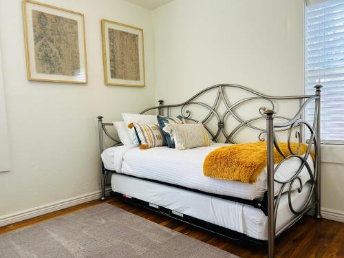a bedroom with a metal bed with pillows on it at Home Sweet Idahome, feels like home with all the decor you wish you could afford King bed in master, fully fenced dog friendly yard, a few blocks from BSU and downtown Boise, Your perfect stay! in Boise