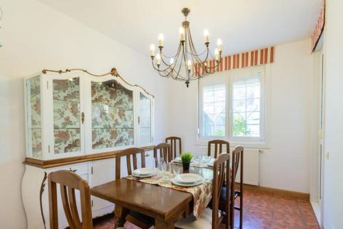 comedor con mesa, sillas y lámpara de araña en KANPONDOA ETXEA, en Aoiz